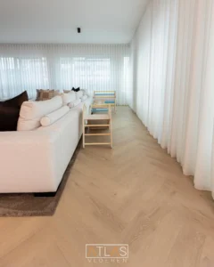 Lichte woonkamer met visgraatvloer en gordijnen
